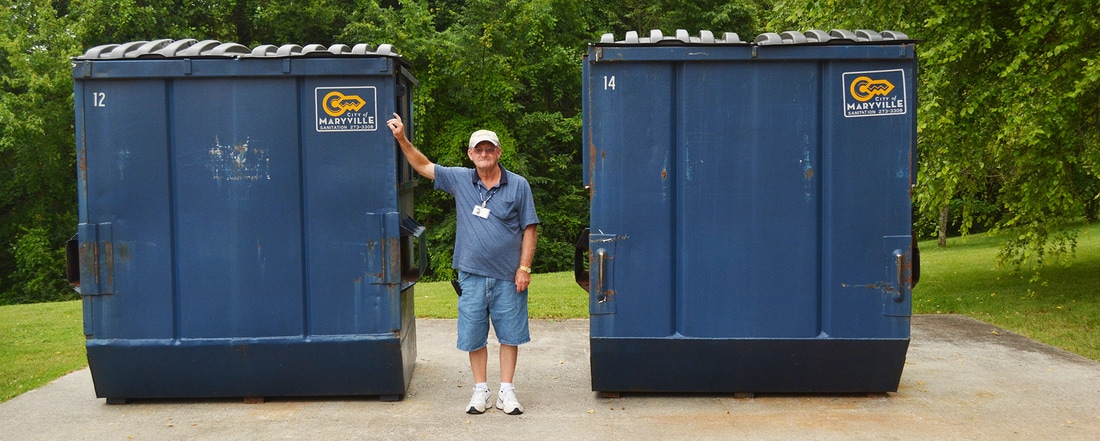 Photo of employee with recycling bins
